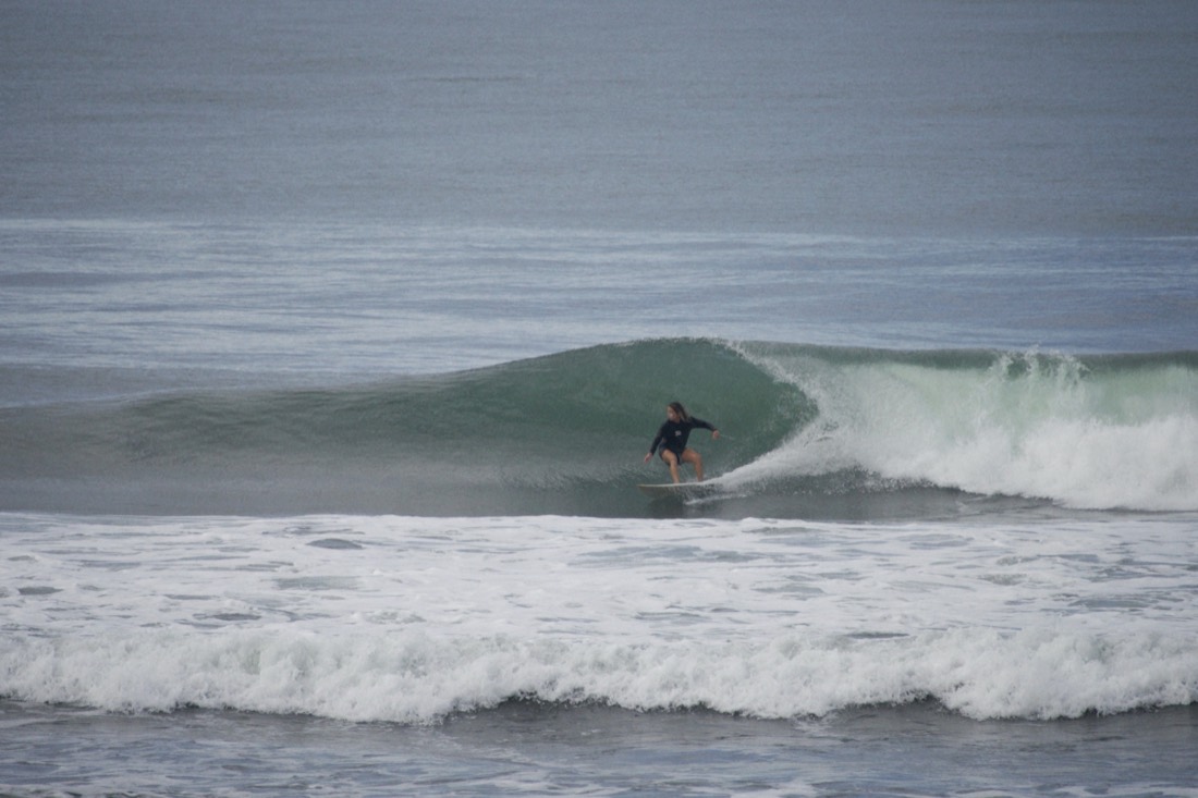 Surfer riding a clean wave in Jacó