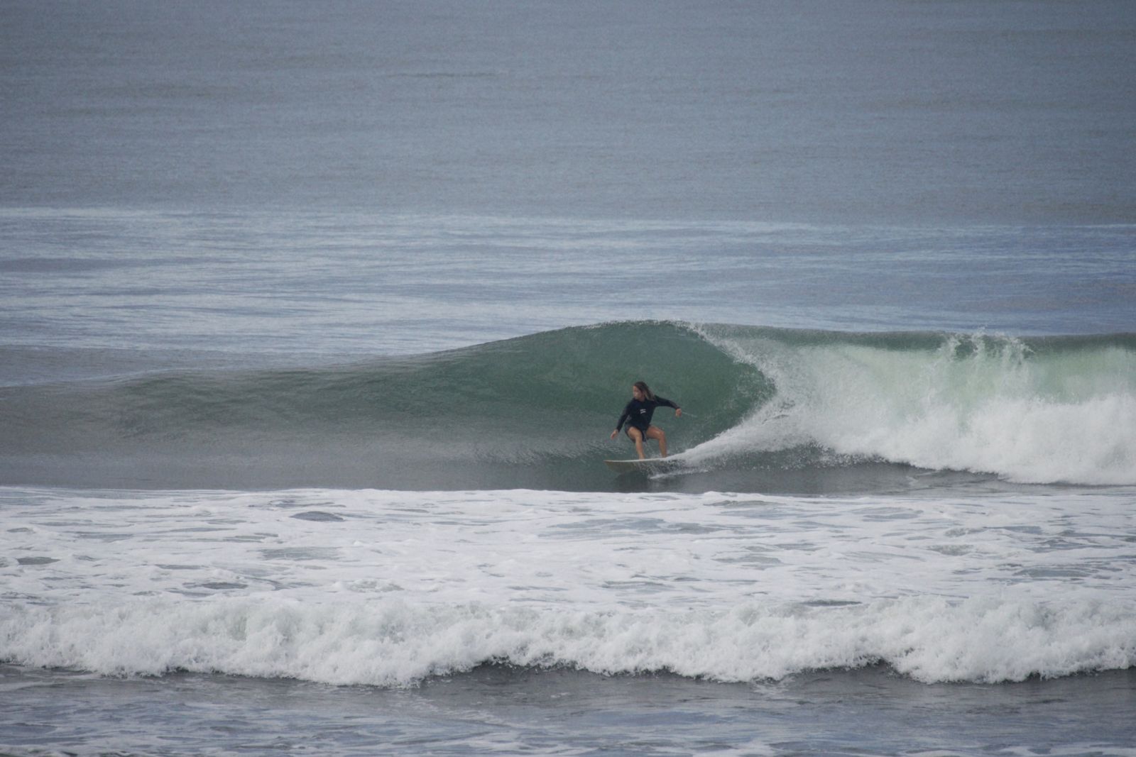 A surfer tucked into a wave at Jacó