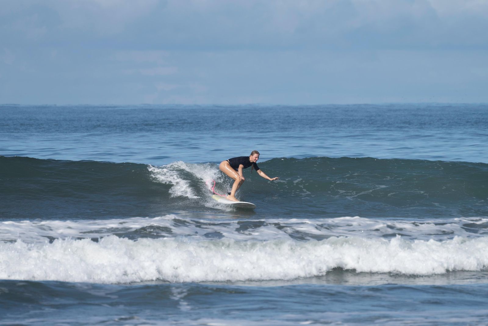 A surfer riding a clean wave at Jacó